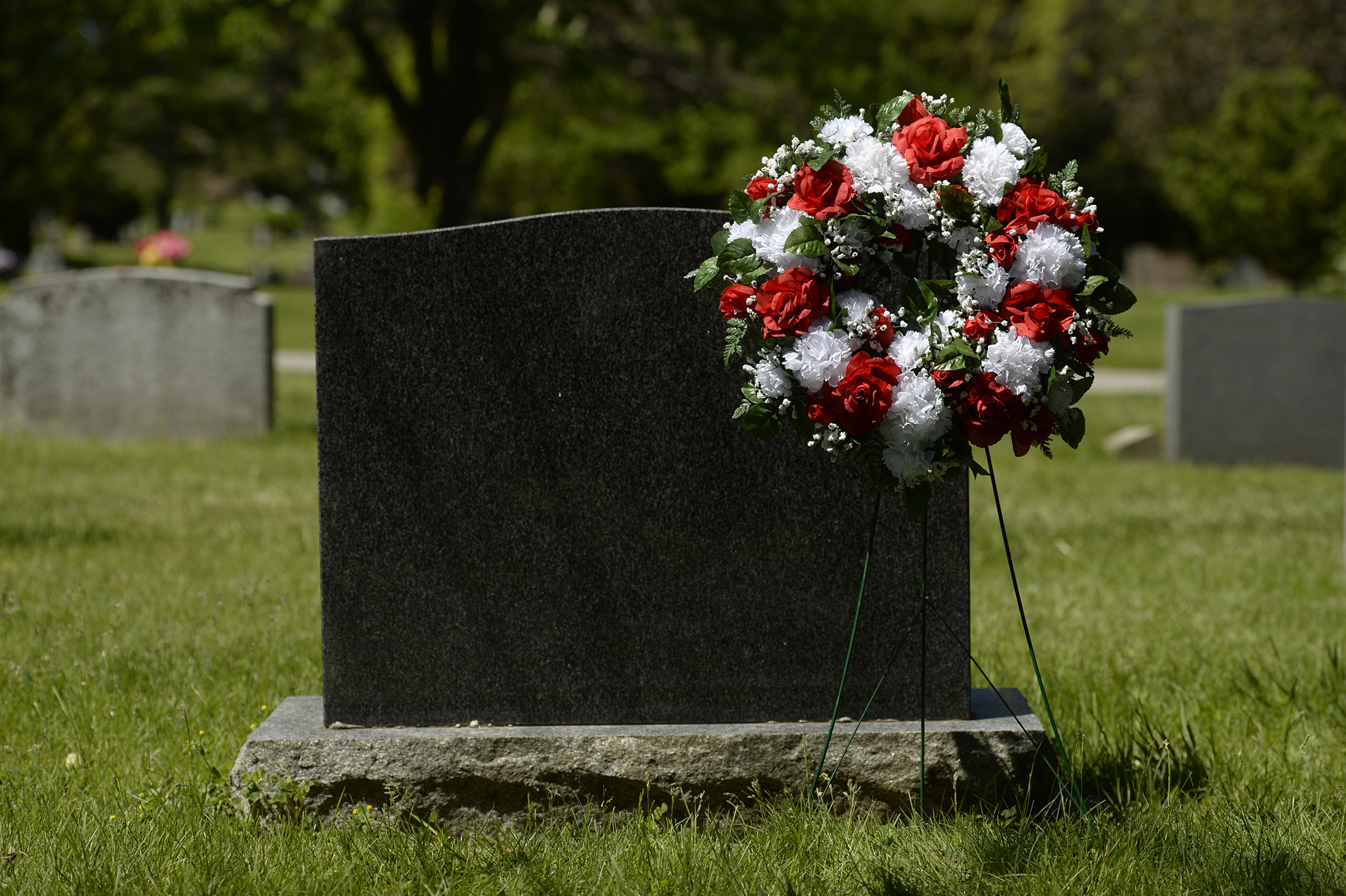 red and white wreath beside a monument