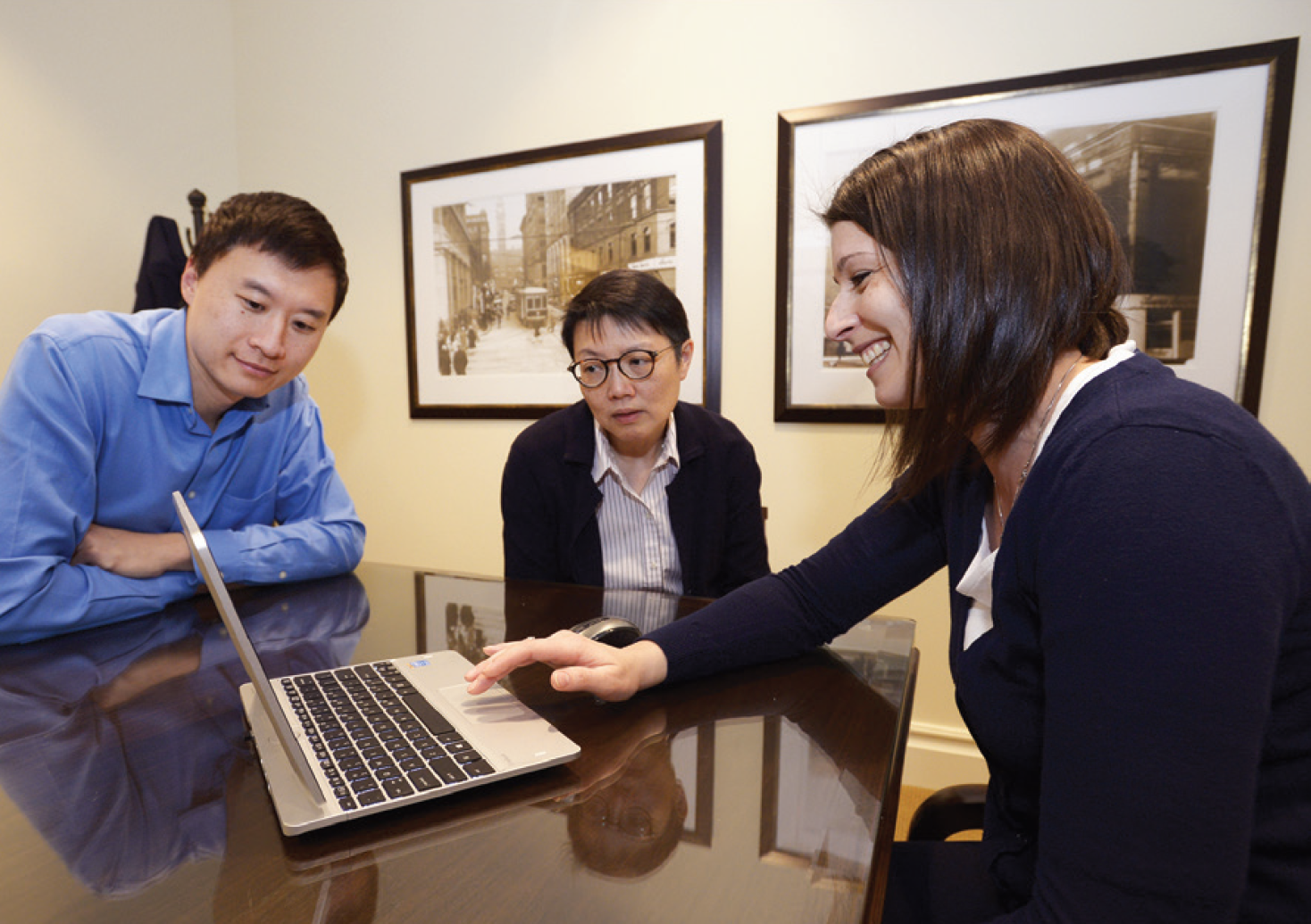 Funeral preplanner meeting with clients, reviewing arrangements on a laptop.