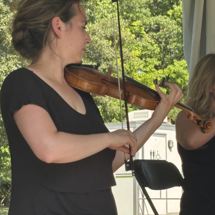 a woman in black playing the violin