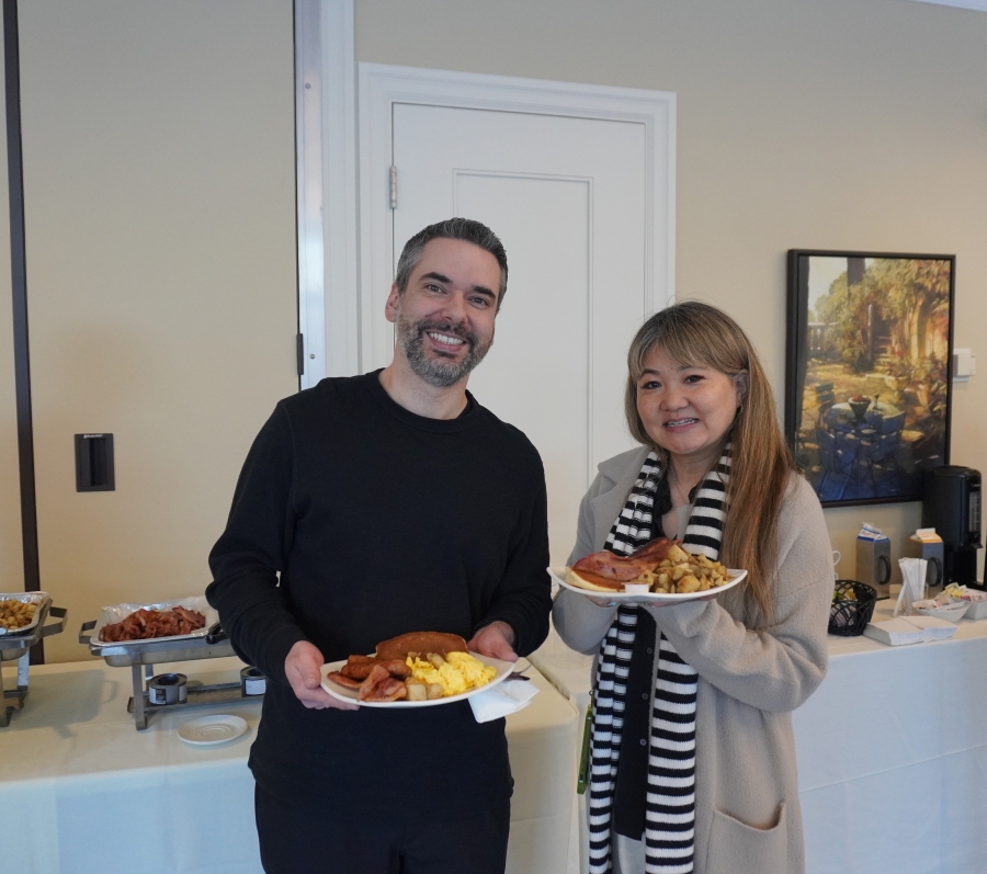 two people posing with plates of food