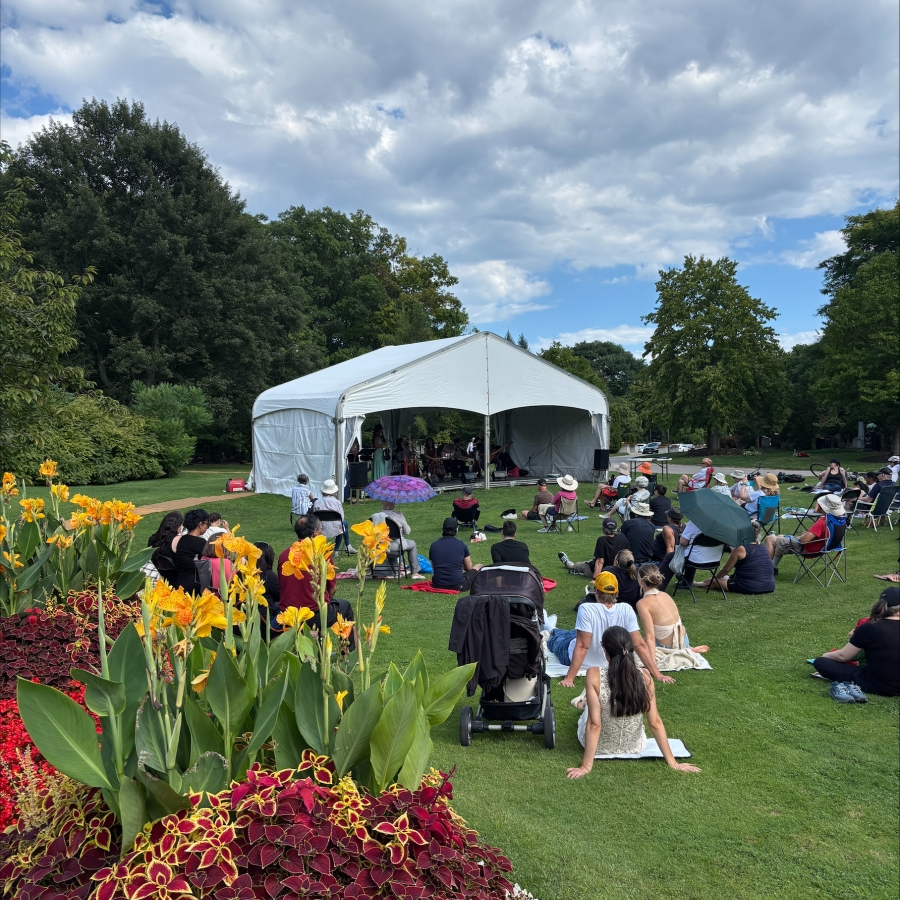 blue sky with clouds and people sitting by a tent listening to music