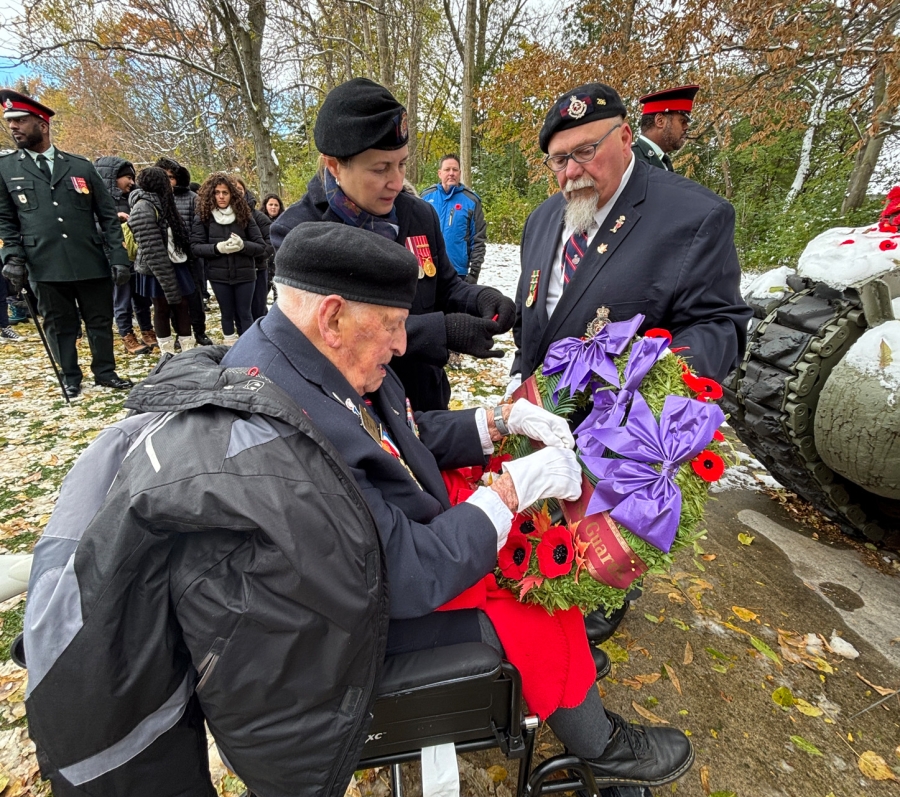 Veteran in a wheelchair holding a wreath during Remembrance Day service at York Cemetery.
