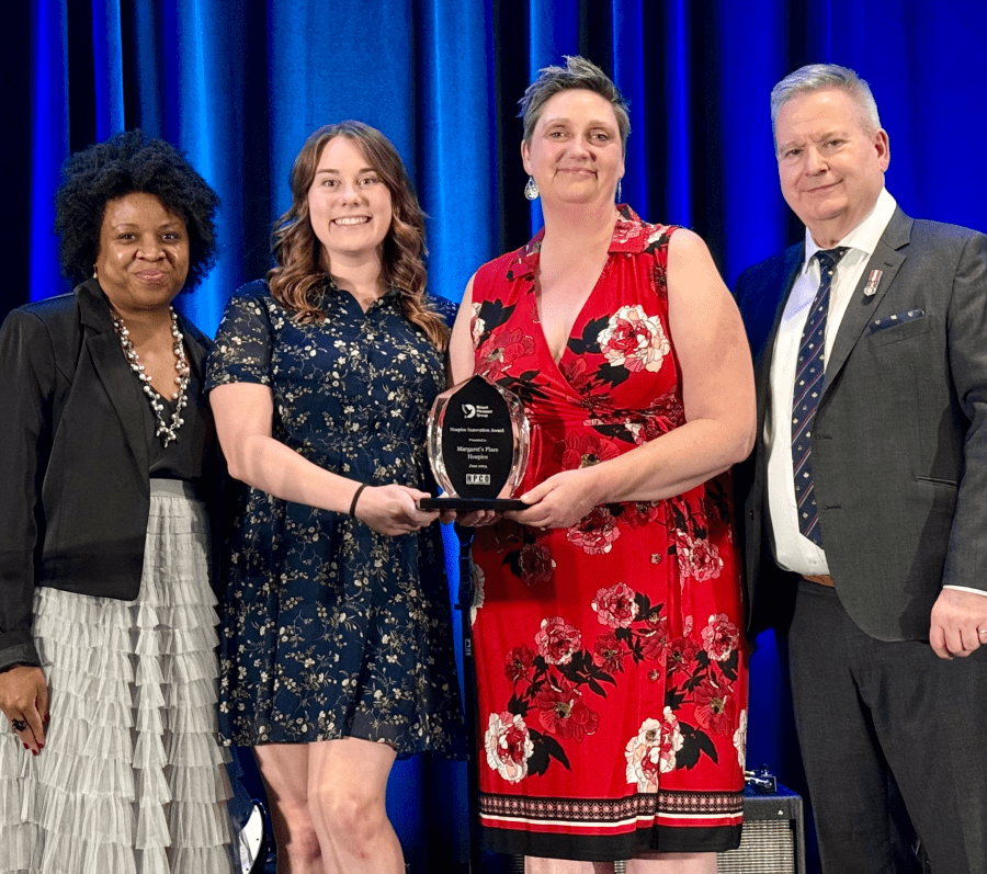four people posing with an award