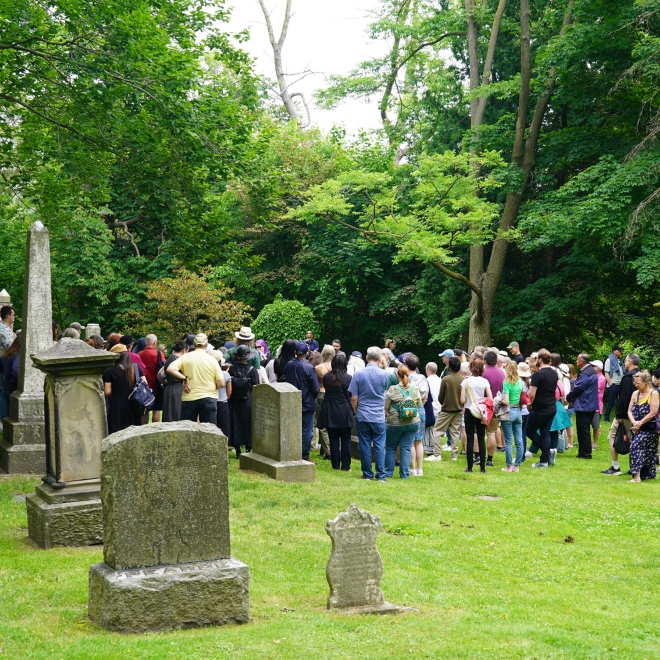 Participants on a guided history walk among old grave markers.