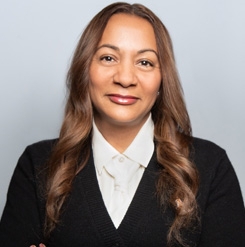 Copilot said: Professional headshot of a person wearing a white collared shirt and black sweater.