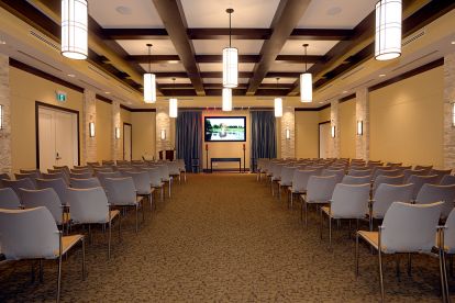 gathering hall with lots of chairs and lighting coming down from ceiling