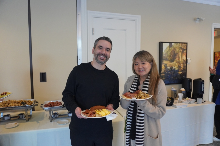 two people posing with plates of food