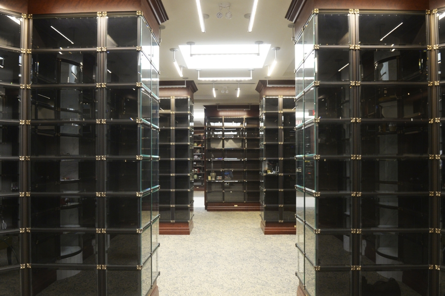 Dark glass display niches with black framing and gold floral corner accents.