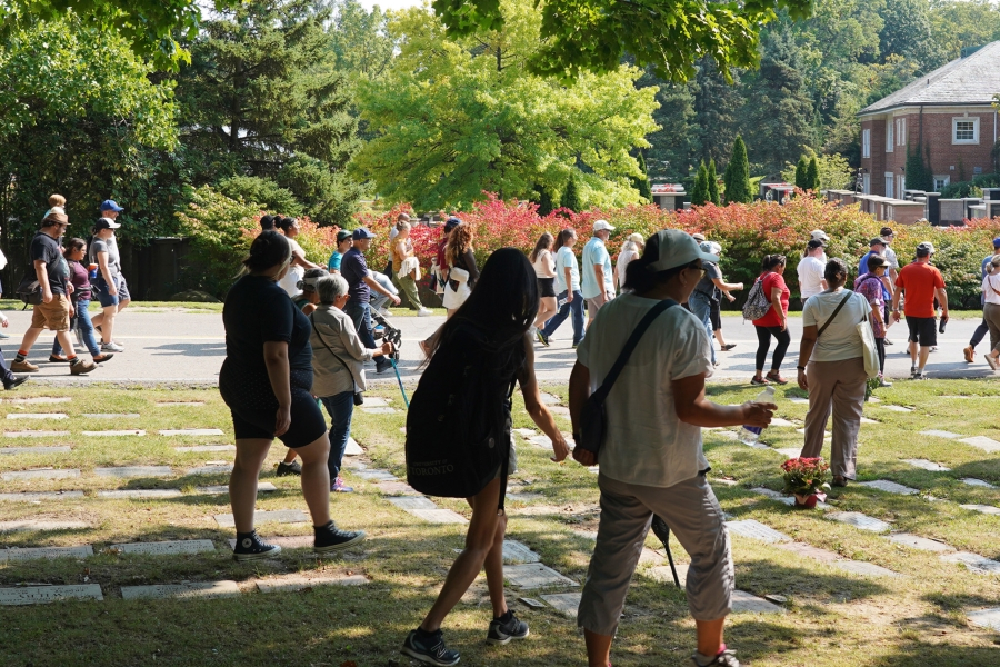 Group of visitors walking through Mount Pleasant Cemetery during a guided history tour.