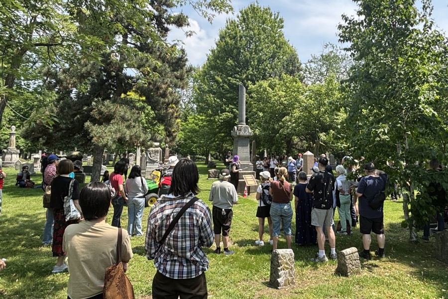 Group gathered at a cemetery memorial during a guided history walk.
