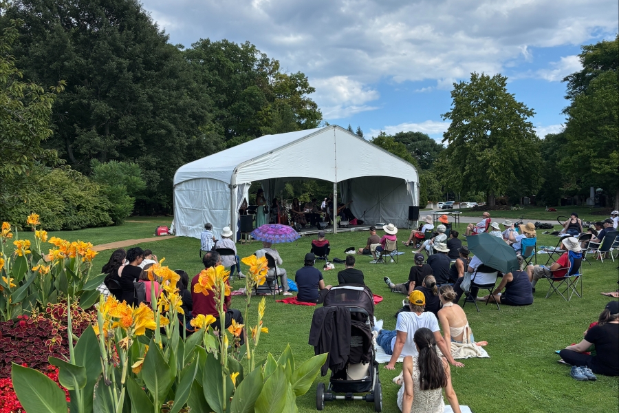 blue sky with clouds and people sitting by a tent listening to music