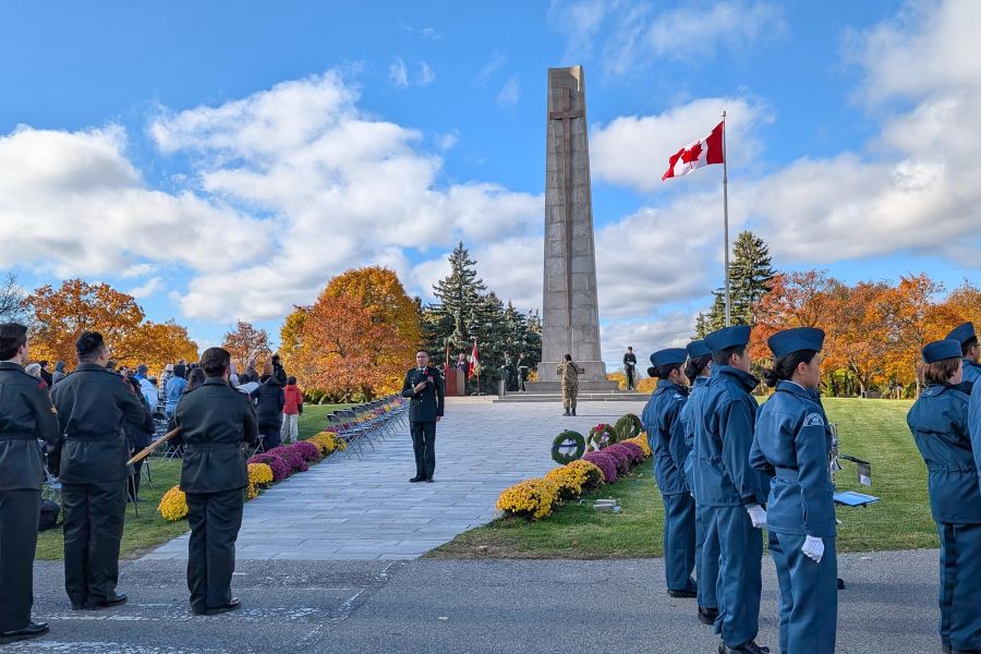 Remembrance Day ceremony at York Cemetery with uniformed personnel near a monument and Canadian flag.