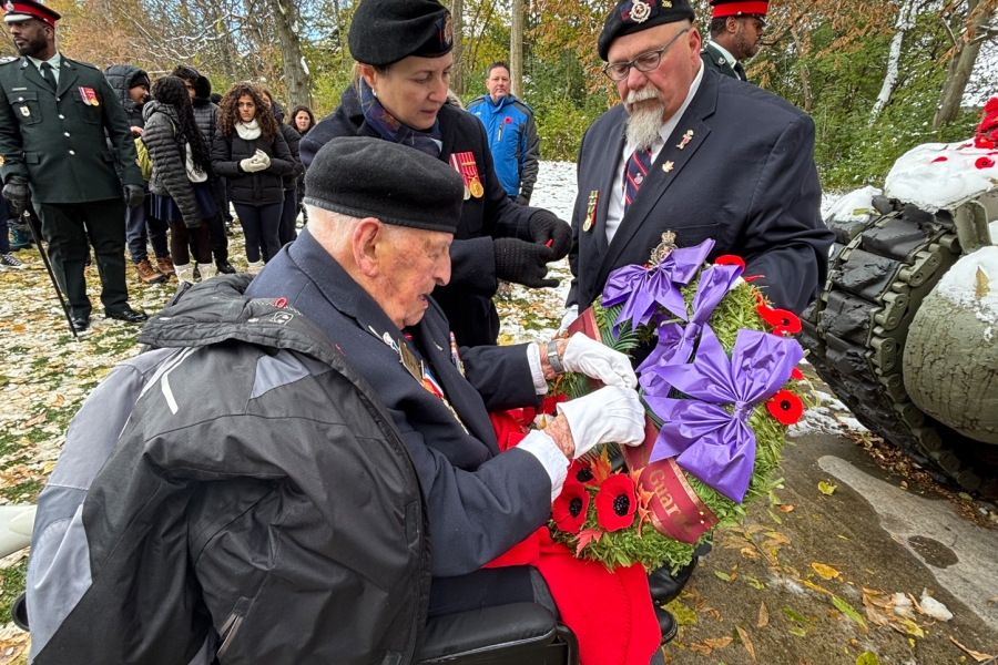 Veteran in a wheelchair holding a wreath during Remembrance Day service at York Cemetery.