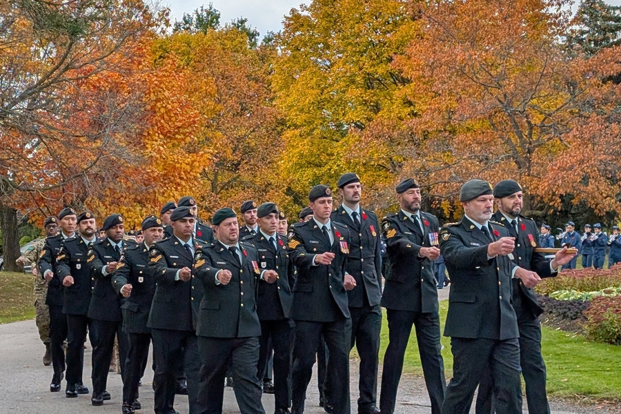Military personnel marching in formation during Remembrance Day service at York Cemetery.