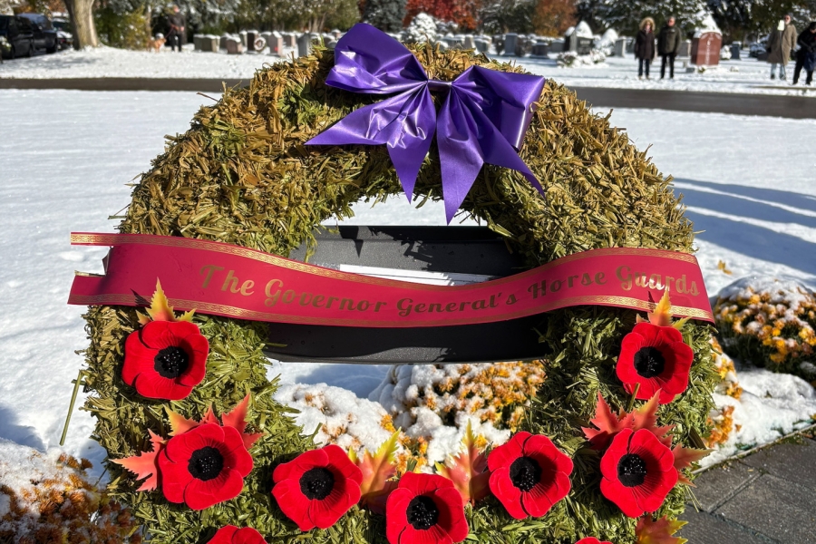 Remembrance Day wreath with red poppies and purple bow displayed at York Cemetery.