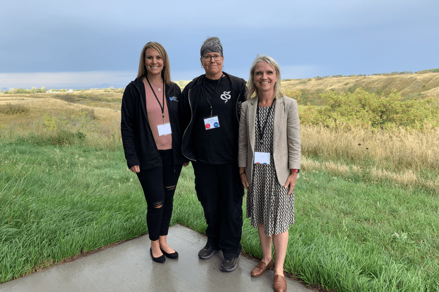 three people posing outside