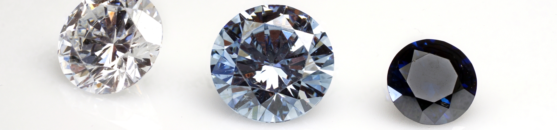 Three round gemstones in clear, light blue, and dark blue on a white background.